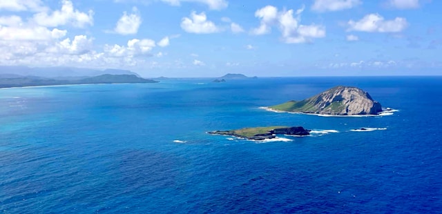 a blue ocean with some small rocky islands